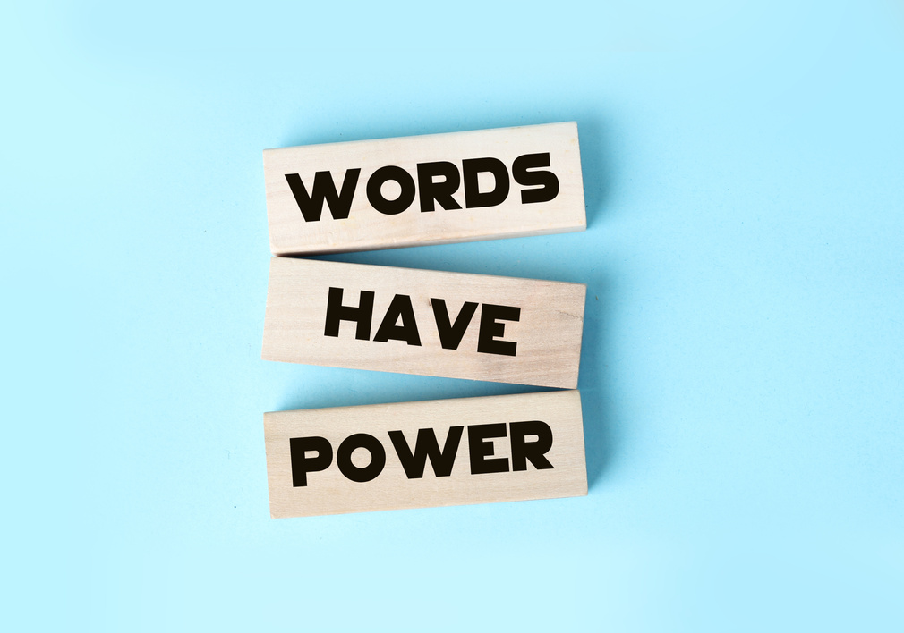 The phrase Words Have Power on wooden blocks laying on blue background. Copywriting advertising PR concept